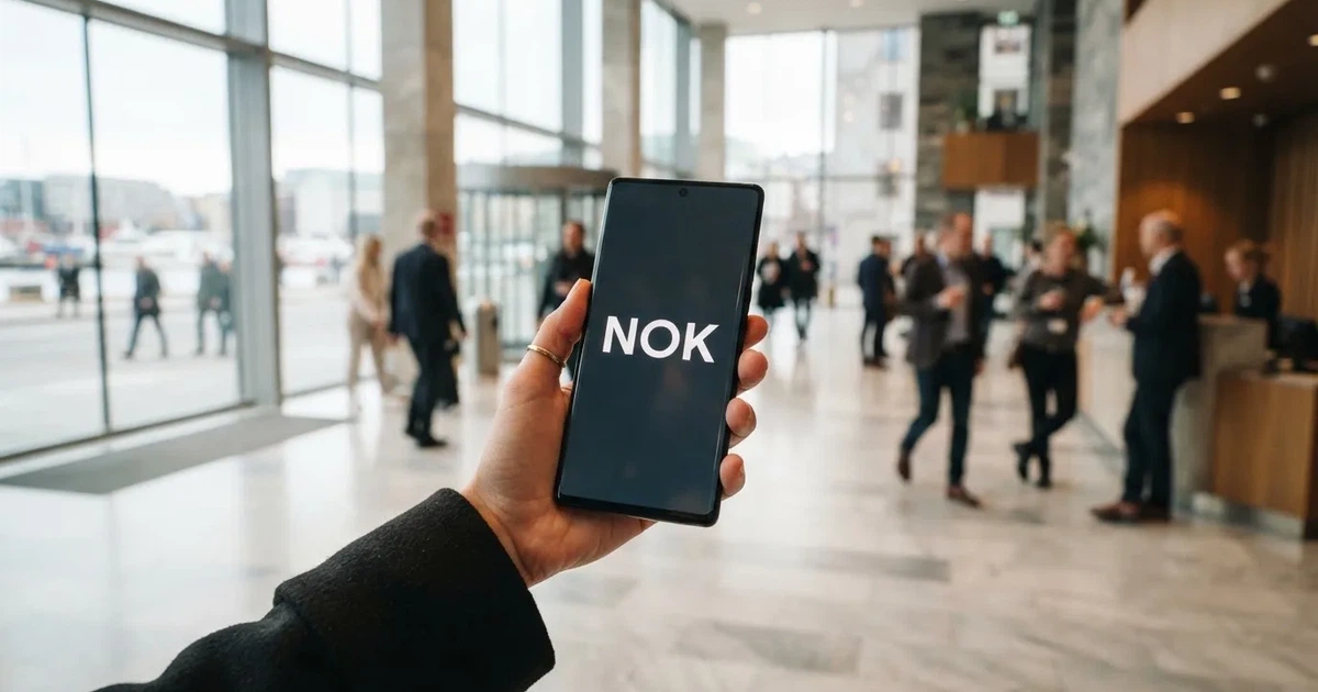 Hånd som tar imot kontanter fra en minibank i en lys foajé, uskarp bakgrunn
